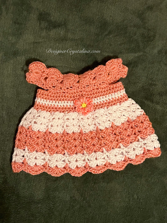 Crocheted dress with pink and white stripes on a dark green background
